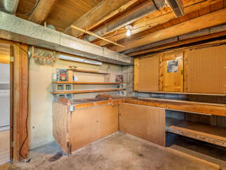 Discover a versatile workshop space in this basement, perfect for DIY projects and storage.