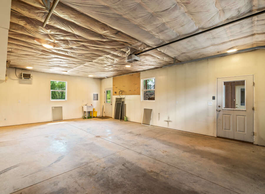 Discover the potential of this spacious garage, featuring a durable concrete floor and ample lighting.