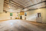 Discover the potential of this spacious garage, featuring a durable concrete floor and ample lighting.