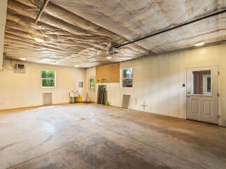Discover the potential of this spacious garage, featuring a durable concrete floor and ample lighting.