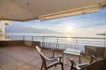 Experience breathtaking panoramic views from this stunning balcony overlooking a serene lake and majestic snow-capped mountains.