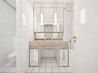 This modern bathroom features a sleek marble vanity with a built-in sink and a large mirrored cabinet above.