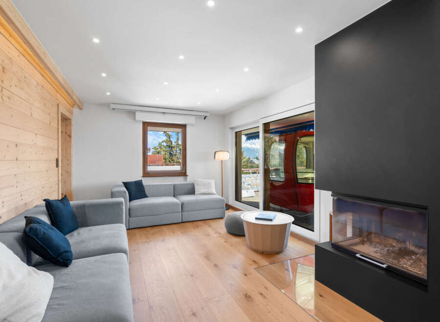 Experience modern living in this stylish living room featuring a comfortable grey sectional sofa adorned with navy blue and white pillows.