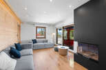 Experience modern living in this stylish living room featuring a comfortable grey sectional sofa adorned with navy blue and white pillows.