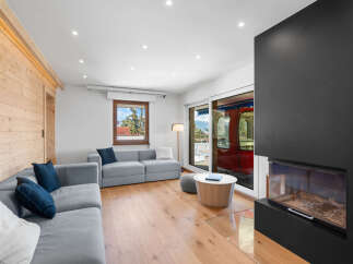 Experience modern living in this stylish living room featuring a comfortable grey sectional sofa adorned with navy blue and white pillows.