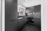 Discover this modern, sleek kitchen featuring dark cabinetry and countertops for a sophisticated look.