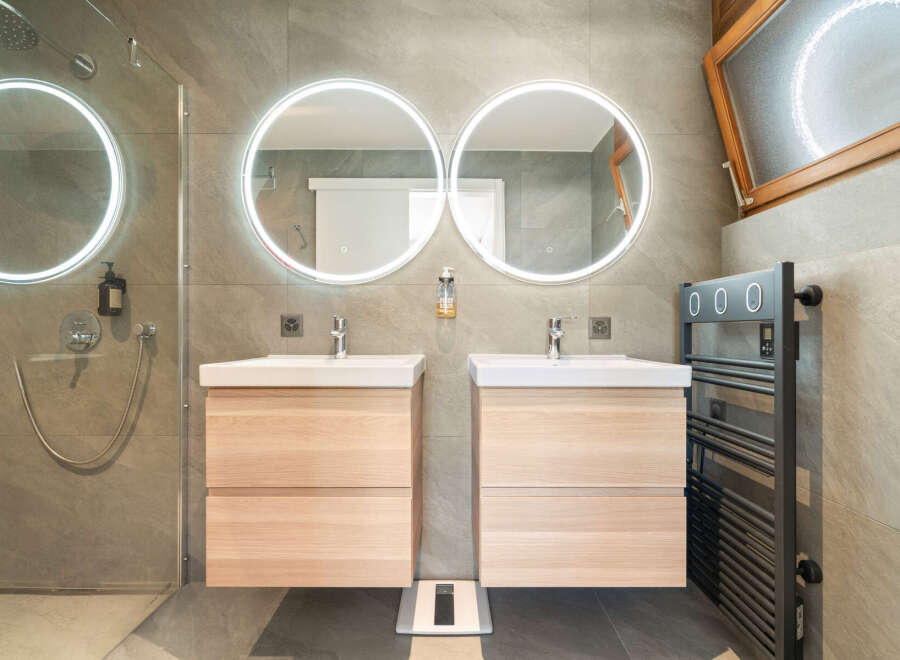 Experience modern luxury in this stunning bathroom featuring dual floating vanities with integrated lighting and sleek faucets.