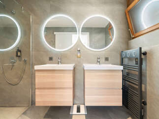 Experience modern luxury in this stunning bathroom featuring dual floating vanities with integrated lighting and sleek faucets.
