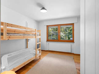 This charming bedroom features a sturdy wooden bunk bed, perfect for families or guests.