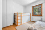 This cozy bedroom features a modern wooden bunk bed with translucent panels, perfect for maximizing space.