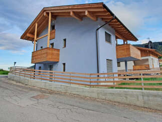 Experience modern alpine living in this stunning property featuring a light blue facade and warm wooden accents.