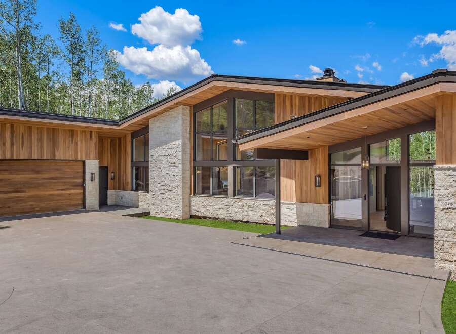 Experience modern luxury in this stunning home featuring natural wood siding and stone accents.
