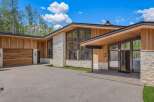 Experience modern luxury in this stunning home featuring natural wood siding and stone accents.