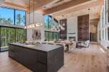 Experience luxury living in this stunning modern home featuring an open-concept living space with soaring ceilings and expansive windows that frame breathtaking forest views.