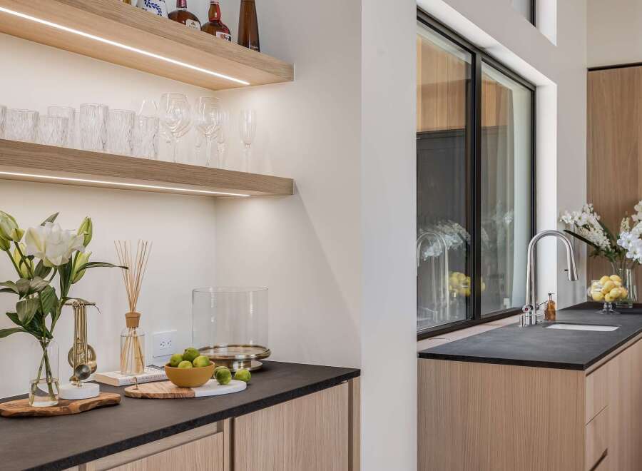 Experience modern luxury in this stunning kitchen featuring sleek, integrated cabinetry and a sophisticated dark countertop.