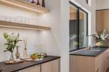 Experience modern luxury in this stunning kitchen featuring sleek, integrated cabinetry and a sophisticated dark countertop.