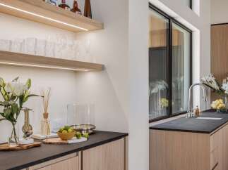 Experience modern luxury in this stunning kitchen featuring sleek, integrated cabinetry and a sophisticated dark countertop.