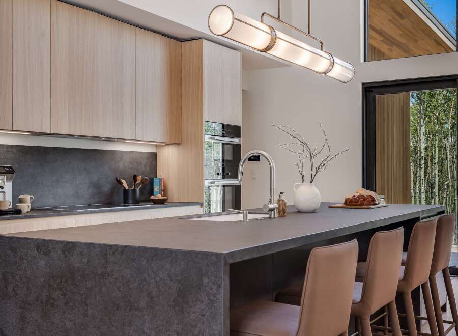 Experience modern luxury in this stunning kitchen, featuring sleek light wood cabinetry and a dramatic dark stone island.