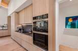Experience modern luxury in this stunning kitchen, featuring sleek, light wood cabinetry and integrated appliances.