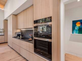 Experience modern luxury in this stunning kitchen, featuring sleek, light wood cabinetry and integrated appliances.