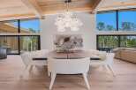 Experience modern luxury in this stunning dining area, featuring a grand walnut dining table surrounded by plush, boucle upholstered chairs.