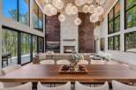 Experience luxury living in this stunning modern home, featuring a grand living area with a soaring ceiling and a magnificent stone fireplace.