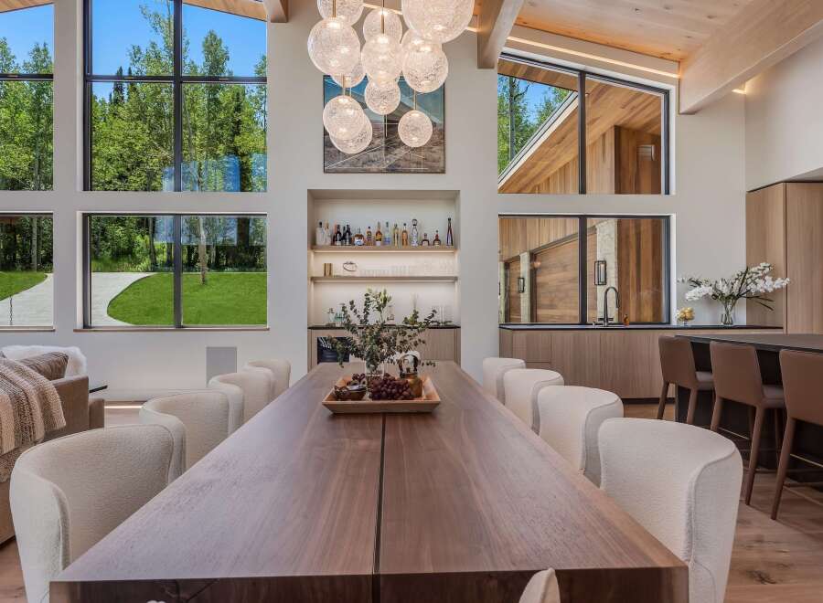 Experience luxury living in this stunning dining area, featuring a grand wooden dining table perfect for gatherings.