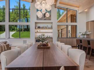 Experience luxury living in this stunning dining area, featuring a grand wooden dining table perfect for gatherings.