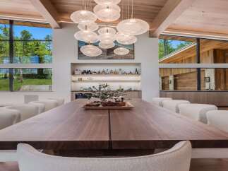 Experience luxurious modern living in this stunning dining room, featuring a grand walnut dining table and plush boucle chairs.