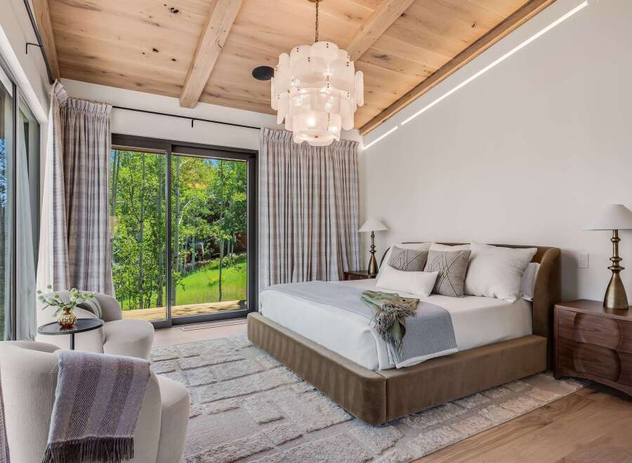 Experience luxury mountain living in this stunning bedroom featuring a plush king-sized bed and elegant seating area.
