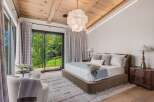 Experience luxury mountain living in this stunning bedroom featuring a plush king-sized bed and elegant seating area.