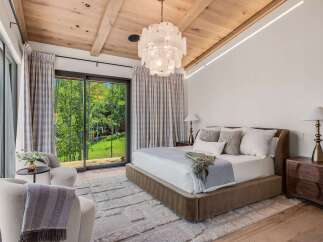 Experience luxury mountain living in this stunning bedroom featuring a plush king-sized bed and elegant seating area.