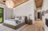 Experience luxury in this master bedroom featuring a plush bed, elegant bedside tables, and a stunning statement chandelier.