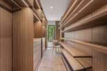 Experience unparalleled organization in this custom walk-in closet, featuring rich wood cabinetry and ample shelving.