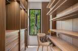 Experience luxurious organization in this modern walk-in closet, featuring rich walnut cabinetry and integrated LED lighting.