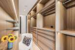 Step into this luxurious walk-in closet, featuring custom wood cabinetry with integrated LED lighting for a sophisticated ambiance.