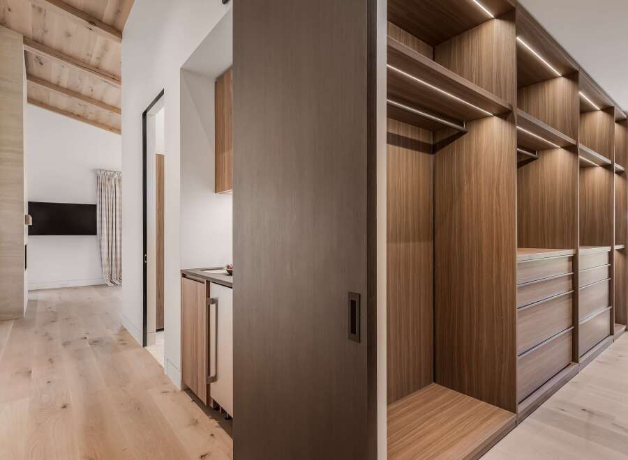 Step into a luxurious walk-in closet featuring custom wood cabinetry and ample storage space.
