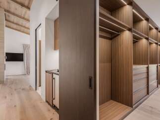 Step into a luxurious walk-in closet featuring custom wood cabinetry and ample storage space.
