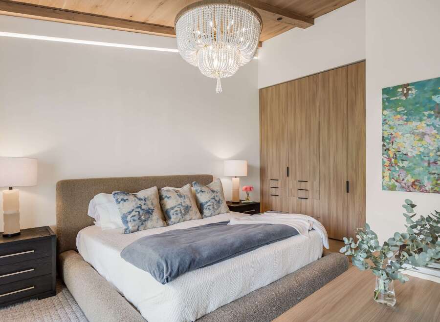 Experience luxurious comfort in this master bedroom, featuring a plush upholstered bed and elegant bedside tables.