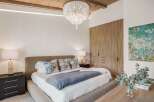 Experience luxurious comfort in this master bedroom, featuring a plush upholstered bed and elegant bedside tables.