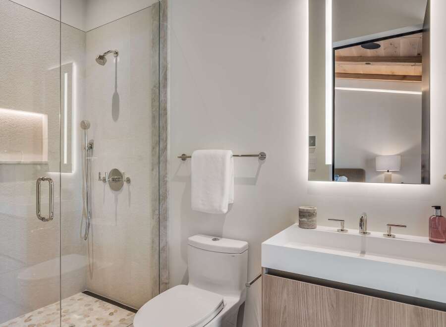 Experience modern luxury in this stunning bathroom, featuring a spacious glass-enclosed shower with elegant tile work and integrated lighting.