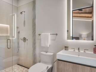 Experience modern luxury in this stunning bathroom, featuring a spacious glass-enclosed shower with elegant tile work and integrated lighting.
