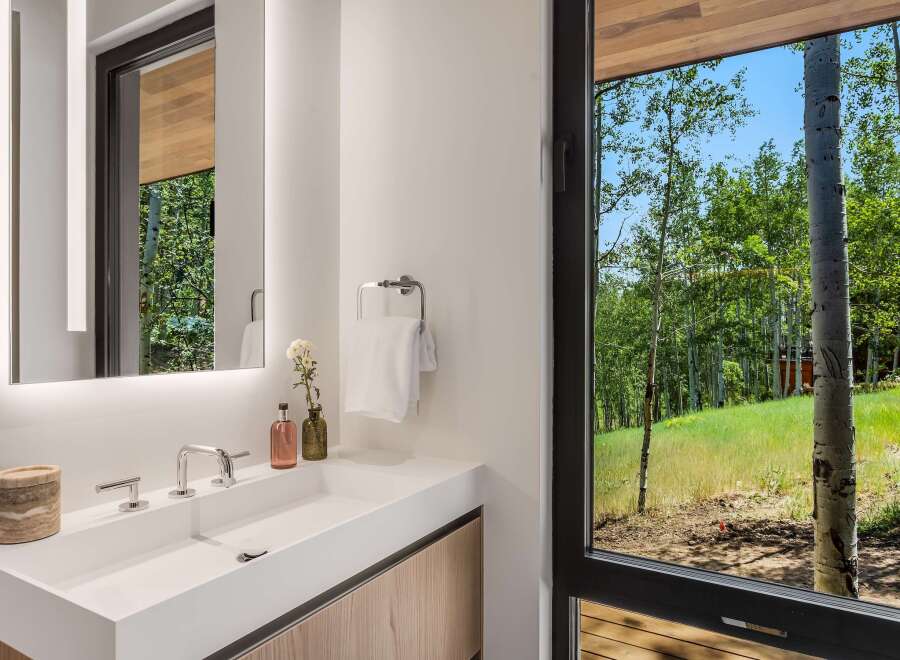 Experience modern luxury in this stunning bathroom, featuring a sleek white vanity with integrated sink and polished chrome fixtures.