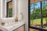 Experience modern luxury in this stunning bathroom, featuring a sleek white vanity with integrated sink and polished chrome fixtures.