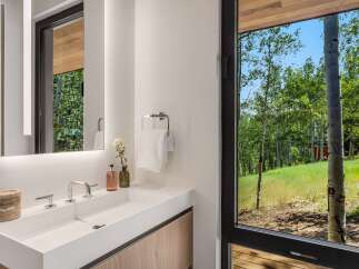 Experience modern luxury in this stunning bathroom, featuring a sleek white vanity with integrated sink and polished chrome fixtures.