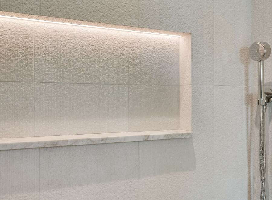 Experience modern luxury in this bathroom featuring a sleek, recessed niche with integrated LED lighting, perfect for displaying toiletries or decor.