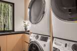 This laundry room boasts a modern, stacked washer and dryer set, perfect for maximizing space in your home.