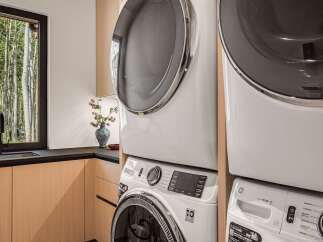 This laundry room boasts a modern, stacked washer and dryer set, perfect for maximizing space in your home.