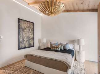 Experience luxury in this master bedroom, featuring a king-sized bed with a plush headboard and a striking botanical artwork.