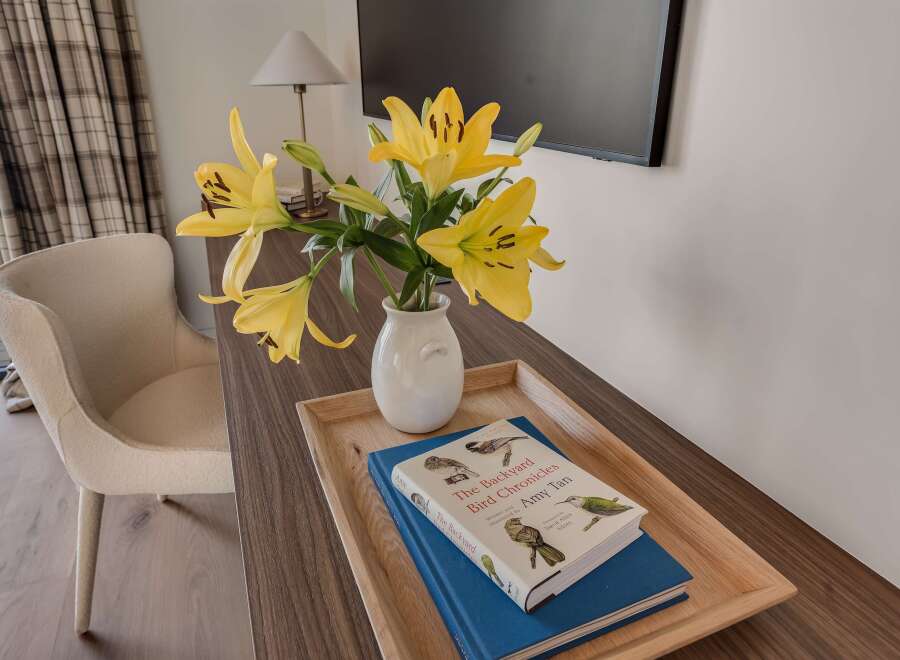 This inviting space features a comfortable armchair and a stylish wooden desk, perfect for work or relaxation.
